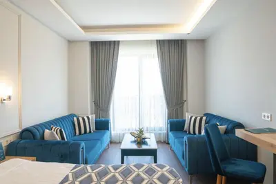 a living room with blue couches and a window at Sakarya Hotel in Sakarya