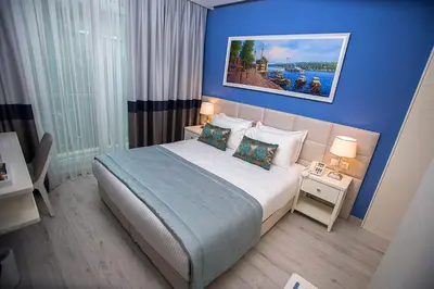 a bedroom with a large bed with a blue wall at Ravvda Hotel in Istanbul