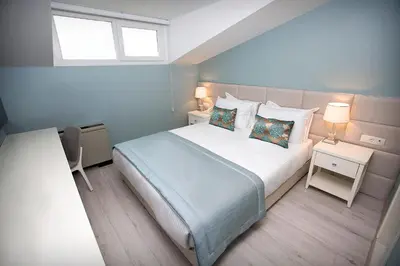 a bedroom with a bed and two lamps and a window at Ravvda Hotel in Istanbul