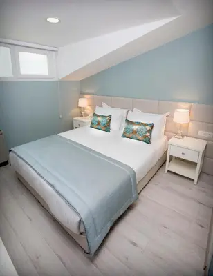 a bedroom with a large white bed with two lamps at Ravvda Hotel in Istanbul