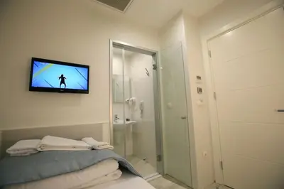 a bathroom with a television on a wall with a bed at Ravvda Hotel in Istanbul
