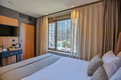 a bedroom with a large bed and a large window at Root Hotel Karaköy Bosphorus in Istanbul