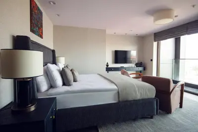 a hotel room with a large bed and a chair at Root Hotel Karaköy Bosphorus in Istanbul