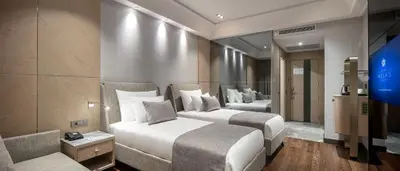 a hotel room with two beds and a television at Melas Hotel Istanbul in Istanbul