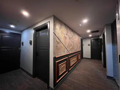 a hallway with black doors and a stone wall at White Corner Hotel in Istanbul