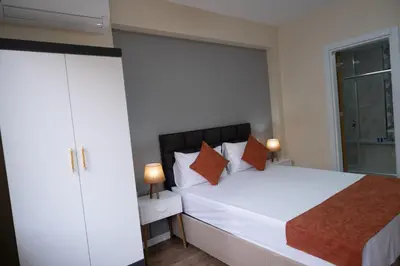 a bedroom with a large white bed with orange pillows at GREEN SUITES BURSA in Bursa