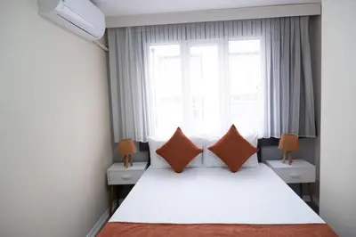 a bedroom with a white bed with pillows and a window at GREEN SUITES BURSA in Bursa