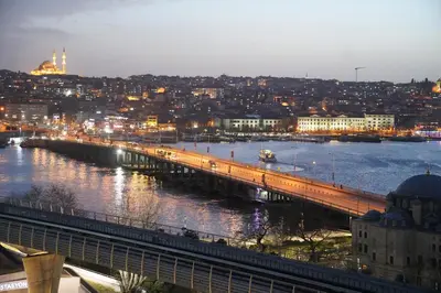 a bridge over a river with a city at night at The Halich Hotel Istanbul Karakoy - Special Category in Istanbul