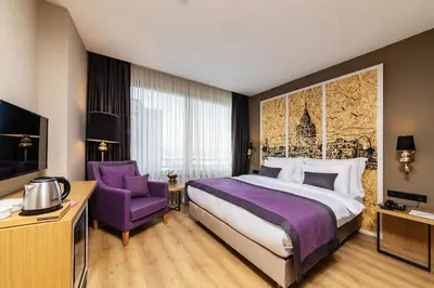 a hotel room with a bed and a purple chair at The Halich Hotel Istanbul Karakoy - Special Category in Istanbul