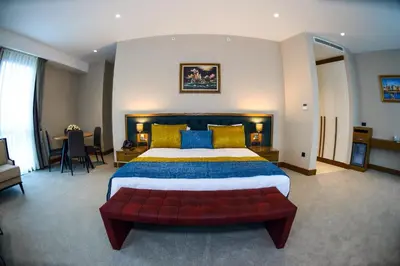 a large bedroom with a large bed and a red couch at CHER HOTEL & SPA Taksim in Istanbul