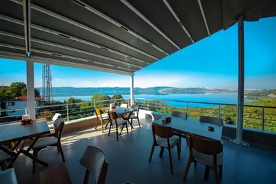 a balcony with tables and chairs and a view of the water at Sapanca View Hotel in Sapanca