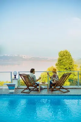 a man and woman sitting in chairs next to a swimming pool at Sapanca View Hotel in Sapanca