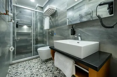a bathroom with a sink and a shower and a toilet at FRT AİRPORT OTEL in Arnavutköy