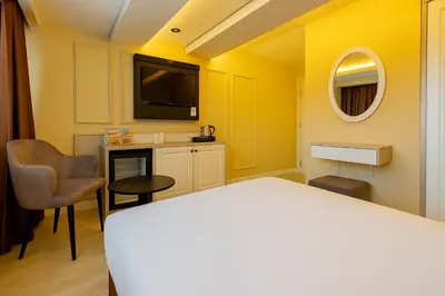 a hotel room with a bed and a tv at FRT AİRPORT OTEL in Arnavutköy