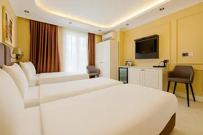 a hotel room with two beds and a television at FRT AİRPORT OTEL in Arnavutköy