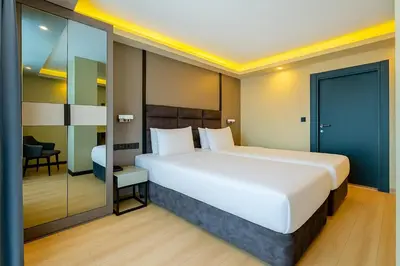 a bedroom with a large white bed in a room at FRT AİRPORT OTEL in Arnavutköy