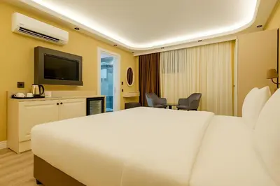 a hotel room with a bed and a television at FRT AİRPORT OTEL in Arnavutköy