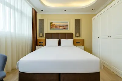 a bedroom with a large white bed in a room at FRT AİRPORT OTEL in Arnavutköy
