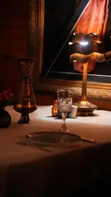 a table with a plate and a lamp and a glass at Treetops Park Hotel in Sile