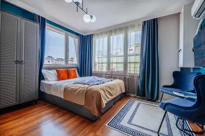 a bedroom with a bed and a desk and windows at Taksim Wonder Suites in Istanbul