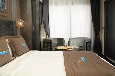 a bedroom with a bed and two chairs and a table at La Cielo Hotel Bostancı in Istanbul