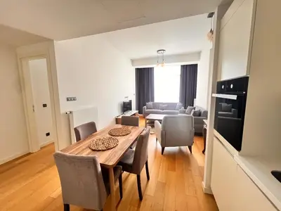 a dining room and living room with a table and chairs at Divan Residence - Güneşli Near Ataköy Metro Station in Istanbul