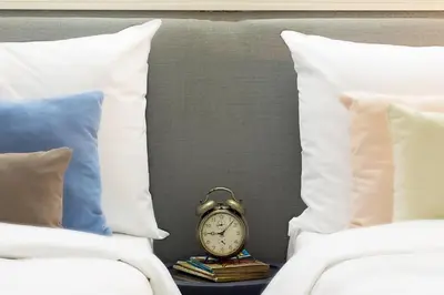 a clock sitting on a night stand between two beds at Anemon Bakırköy in Istanbul