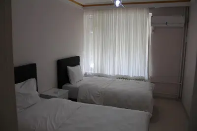 a hotel room with two beds and a window at Abbasi Apart (H) in Çekirge