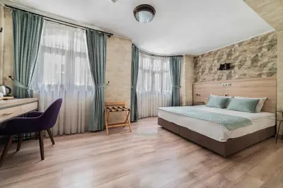 a bedroom with a bed and a table and a desk at Castle Franco Suites in Istanbul