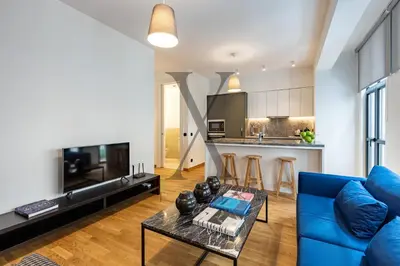 a living room with a blue couch and a table at X Flats Vilhelm in Istanbul