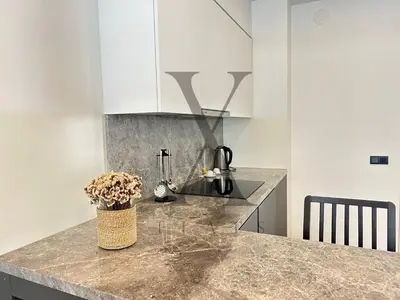 a kitchen with white cabinets and a granite counter top at X Flats Vilhelm in Istanbul