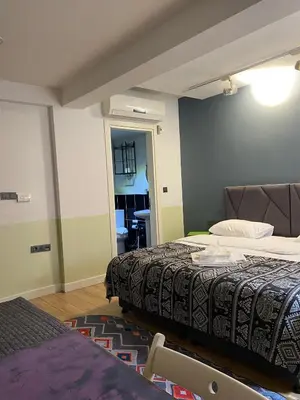 a bedroom with two beds and a table in it at Istanbul Hub Flats in Istanbul