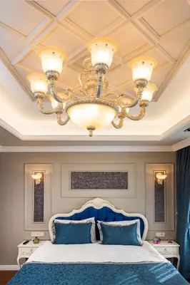 a bedroom with a blue bed and a chandelier at Begonville Mansion Oldcity in Istanbul