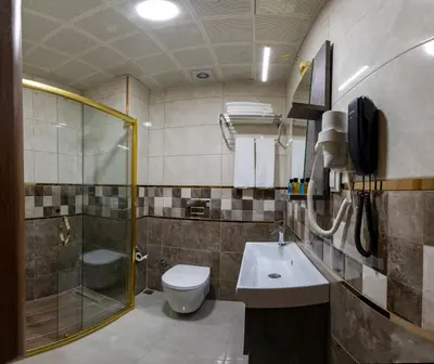 a bathroom with a toilet and a shower and a sink at New Emin Hotel in Istanbul