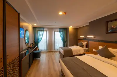 a hotel room with two beds and a mirror at New Emin Hotel in Istanbul