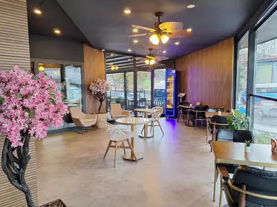 a restaurant with tables and chairs and pink flowers at N'Ala Otel in Sakarya