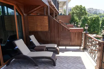 two chairs sitting on a patio with a balcony at Phellos Suites Boutique Hotel in Sile