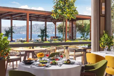a restaurant with tables and chairs with a view of the water at Mandarin Oriental Bosphorus, Istanbul in Istanbul