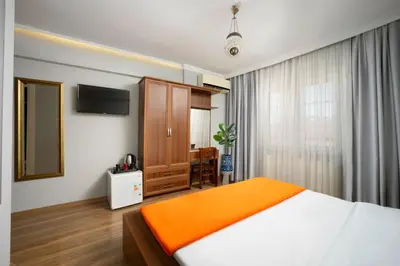 a bedroom with a bed and a cabinet and a television at Sultanahmet Enjoyer Suites in Istanbul