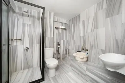 a white bathroom with a toilet and a sink at Sultanahmet Enjoyer Suites in Istanbul
