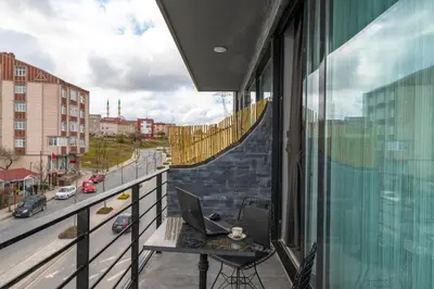 a balcony with a laptop computer sitting on a table at Melanj Airport Hotel in Arnavutköy
