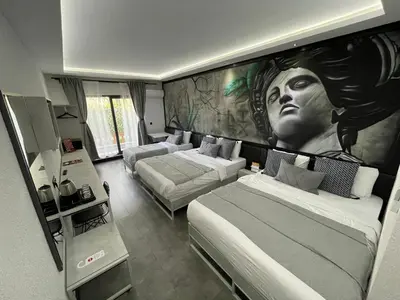 a living room with two beds and a painting on the wall at Melanj Airport Hotel in Arnavutköy