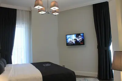 a bedroom with a bed and a tv on the wall at Garlon Residence in Istanbul