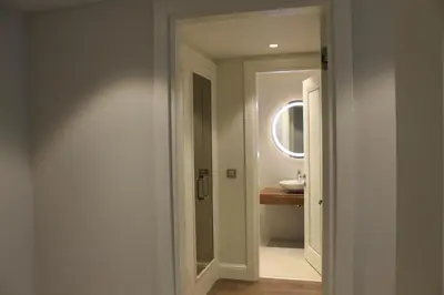 a white bathroom with a sink and a mirror at Garlon Residence in Istanbul