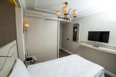 a bedroom with a white bed and a tv at The Charm Hotel - Old City in Istanbul