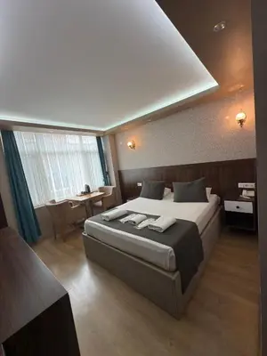 a bedroom with a large bed and a table at ÜSKÜDAR OTEL in Istanbul