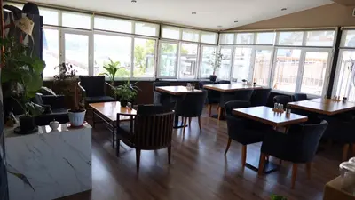 a restaurant with tables and chairs and windows at ÜSKÜDAR OTEL in Istanbul