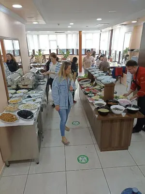 a woman standing in front of a buffet line of food at EMOS HOTEL in Istanbul
