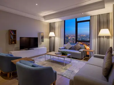 a living room with a couch and a tv at Movenpick Living Istanbul West in Istanbul