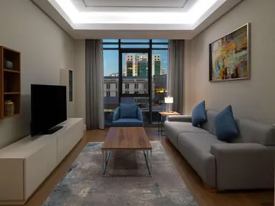 a living room with a couch and a tv at Movenpick Living Istanbul West in Istanbul
